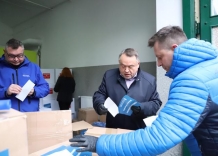 Trzy osoby pakują dary dla Ukrainy wśród nich Piotr Ziętara.