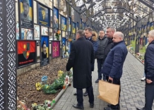 Prezes WMK S.A., inni członkowie Zarządu z władzami Drohobyczam stoją w aleji pełnej zdjęć poległych Ukrainców.